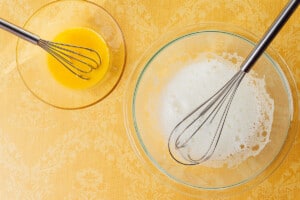 Whisking egg whites and yolks separately.