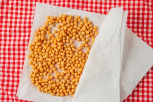 Patting dry chickpeas with paper towels.