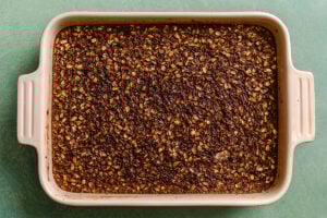 A rectangular baking dish filled with baked oatmeal, showing a dark, evenly browned surface.