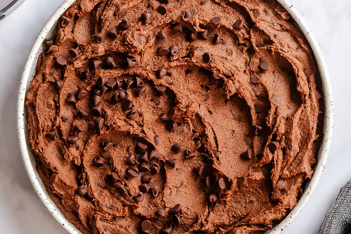 A round bowl filled with chocolate hummus topped with chocolate chips.