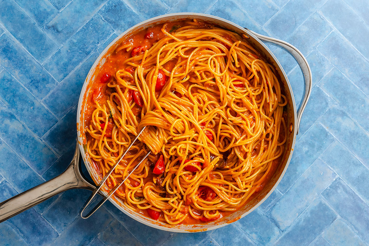 Spaghetti in a tomato sauce served in a stainless steel skillet.