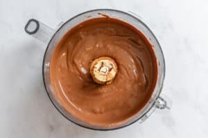 A food processor bowl filled with smooth, blended chocolate mixture.